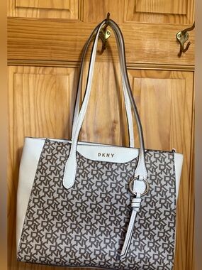 DKNY White and Brown Monogrammed Tote with Gold Ring Accent.
12”W 10.5”Tall X4”D